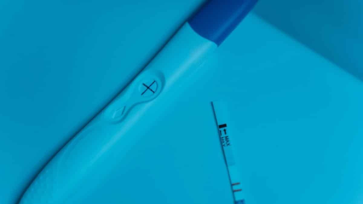 Positive pregnancy test on blue surface, symbolizing new beginnings and family planning.