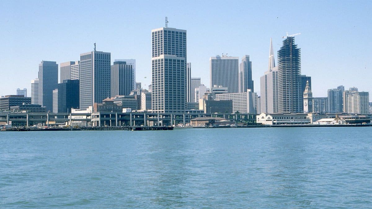 A breathtaking view of San Francisco's iconic skyline with high rises and a calm waterfront.