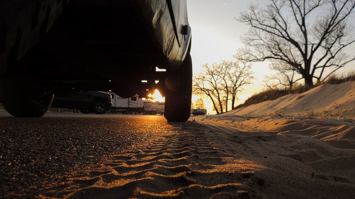 A dramatic perspective of a beach road with sunset and tire tracks in Holland, Michigan.