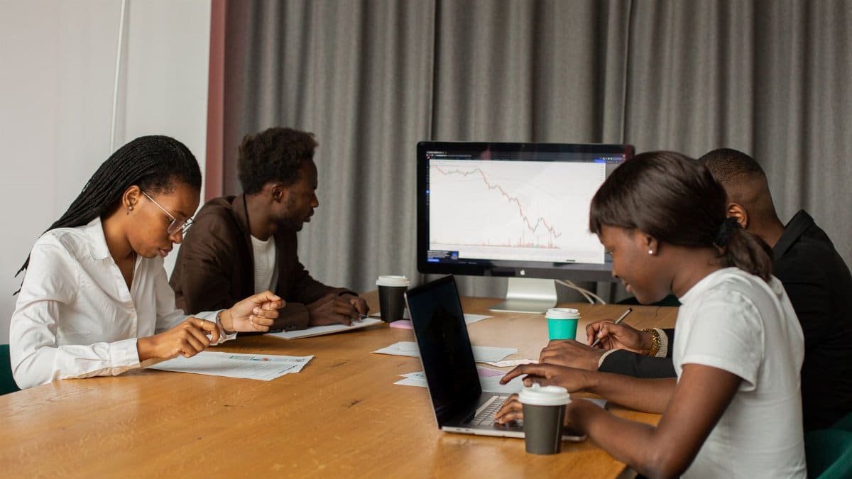 A diverse group of professionals focused on analyzing market data during an office meeting.