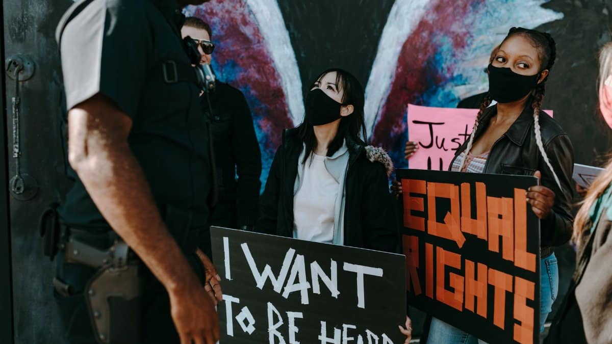 A diverse group protests for equal rights holding banners, seeking justice and unity.