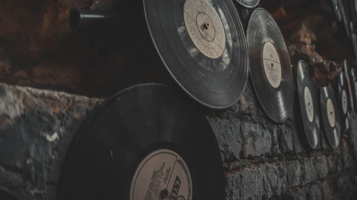 Close-up of vintage vinyl records displayed on a rustic brick wall, creating an artistic, nostalgic atmosphere.