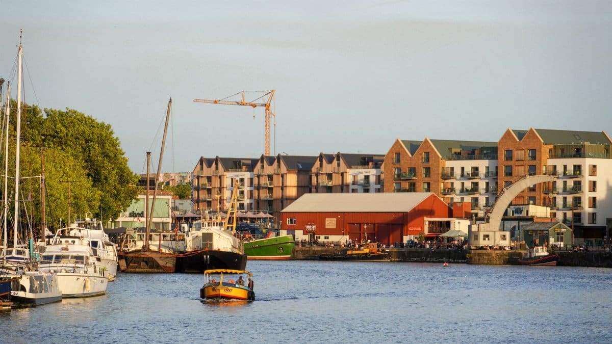 Charming urban waterfront with boats and buildings captured at sunset, creating a serene atmosphere.