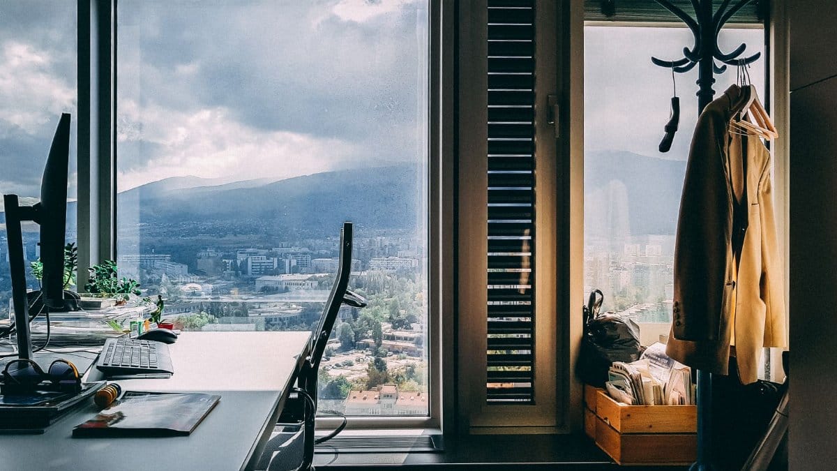 A contemporary office setting with a stunning mountain view through large windows and stylish furnishings.