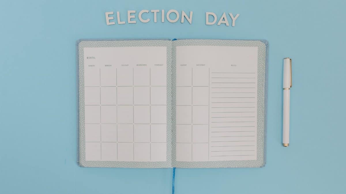 Open planner for Election Day on a bright blue background with a pen