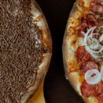 Close-up of chocolate and savory pizza halves on a wooden surface.