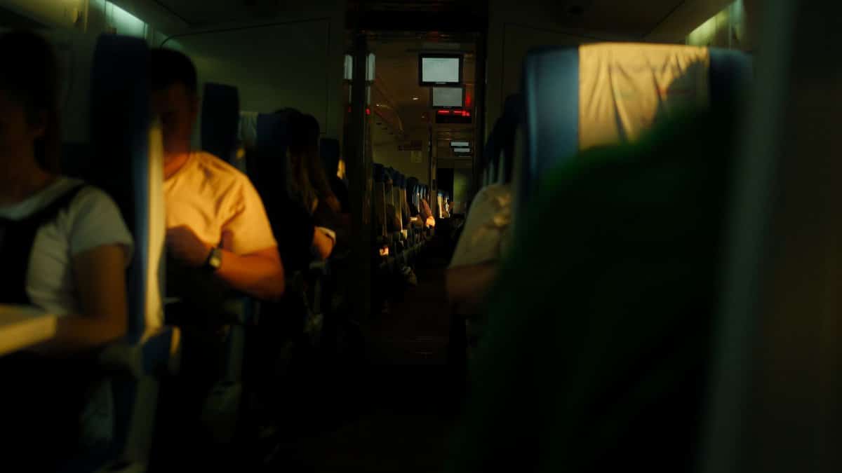 Cozy interior view of an airplane cabin with passengers relaxing during their flight.