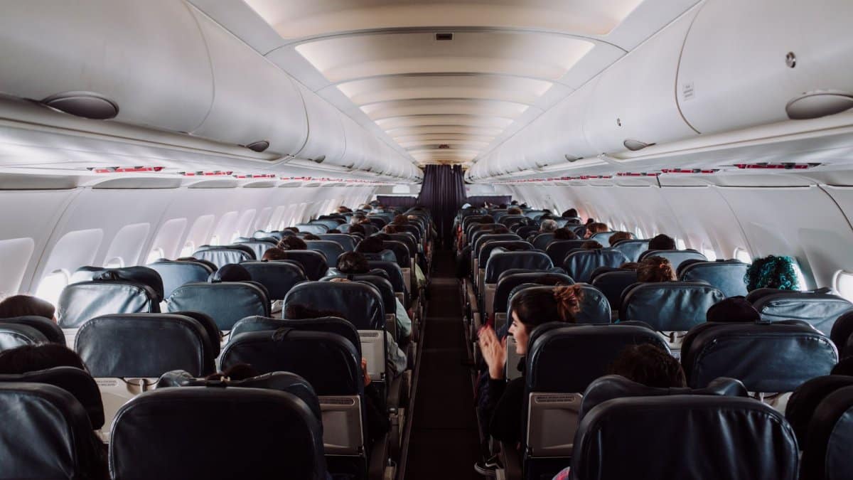 A view of passengers seated inside a commercial airplane cabin during flight.