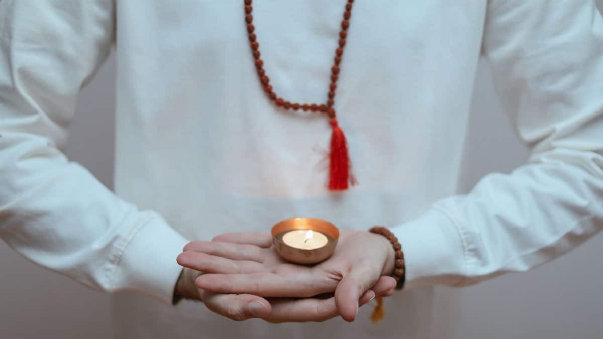 Person holding a candle during meditation, promoting peaceful ambiance and mindfulness.