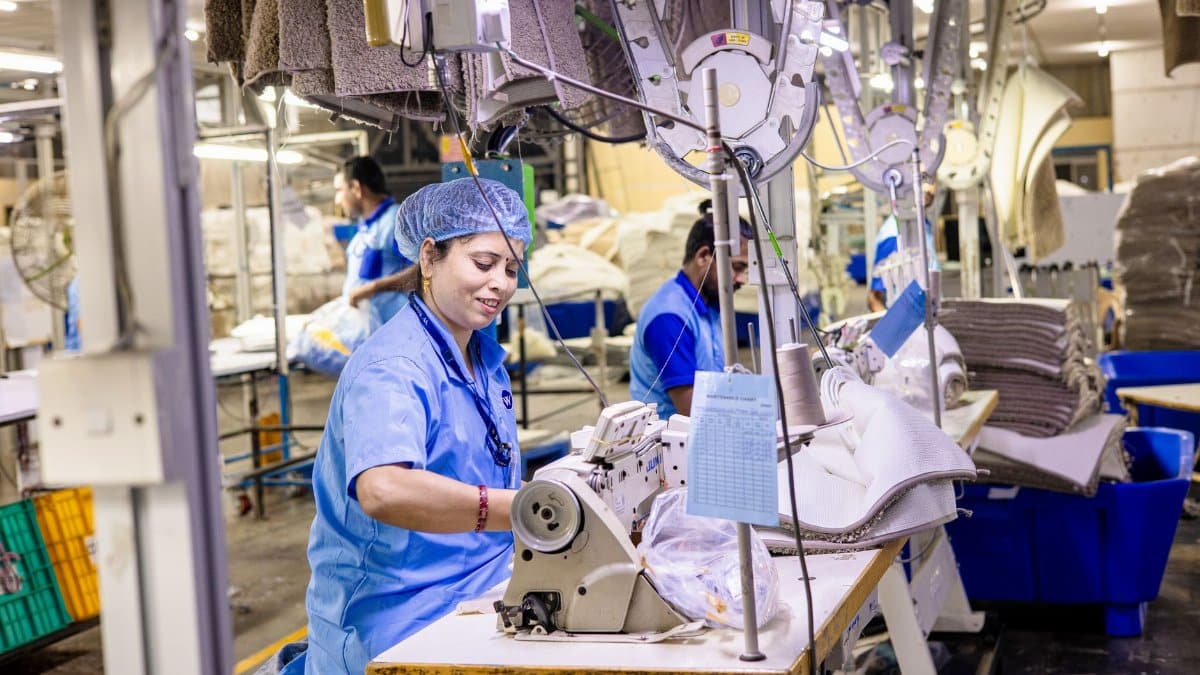 Close-up of textile factory workers operating sewing machines in an industrial setting.