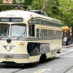 A charming streetcar travels through San Francisco's bustling cityscape on the F Market & Castro line.