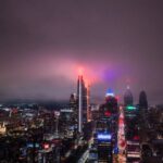 Aerial view of the Philadelphia skyline at night with vibrant city lights illuminating the skyscrapers.