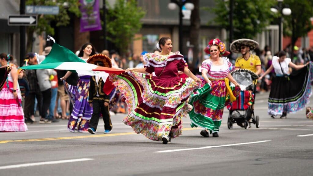 Vibrant Mexican cultural parade with traditional dresses in Victoria, BC streets.