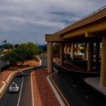 An urban highway scene with overpass and vehicles on a cloudy day, featuring road infrastructure.