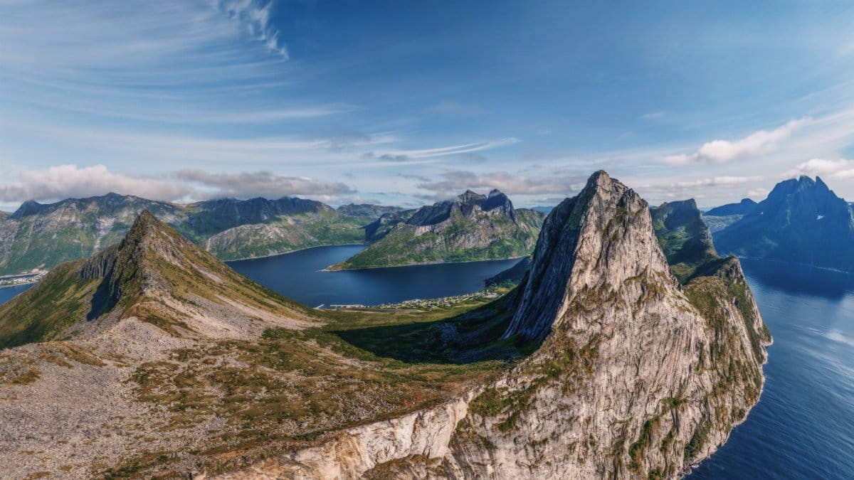 Majestic aerial view of rugged mountain peaks and calm waters in Northern Norway.