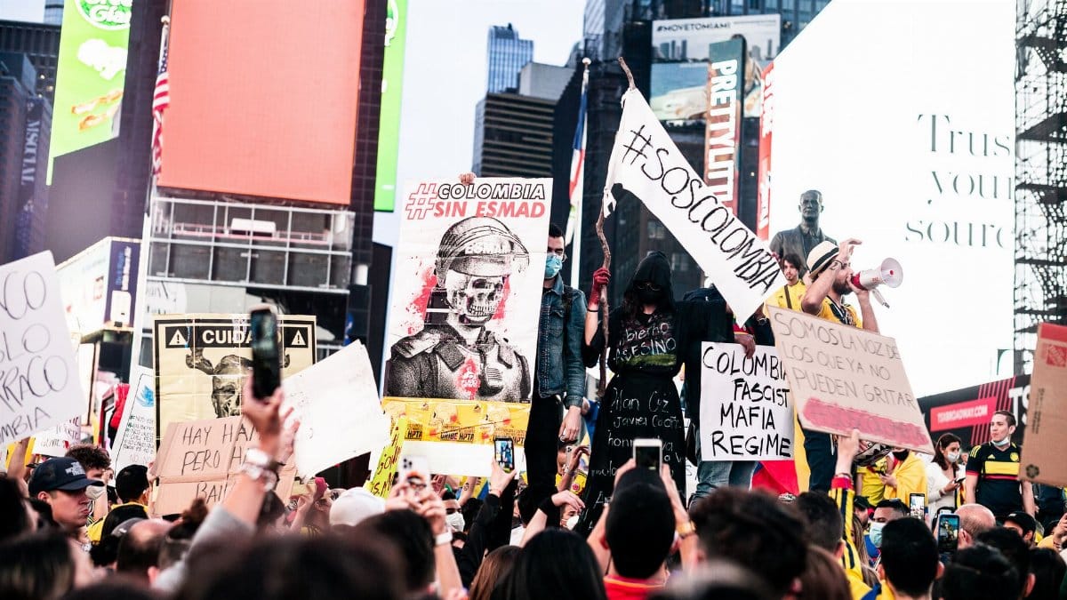 Large protest in Times Square, New York City highlighting political issues and freedom expression.