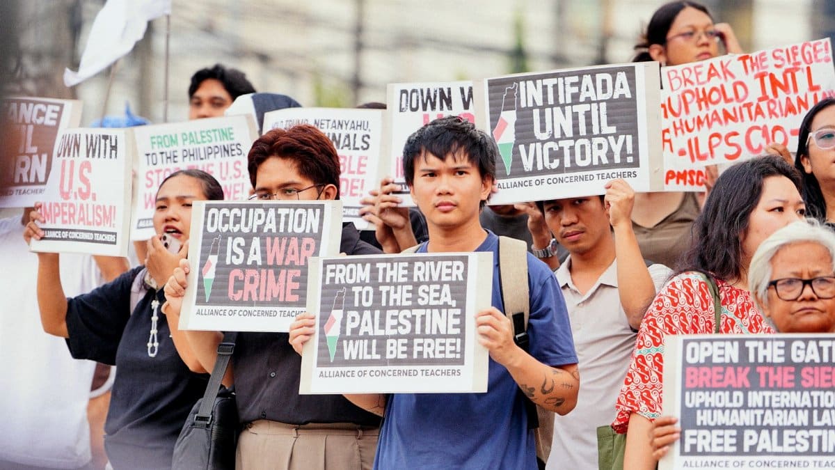 A group of demonstrators holding signs in support of Palestine at a protest rally.