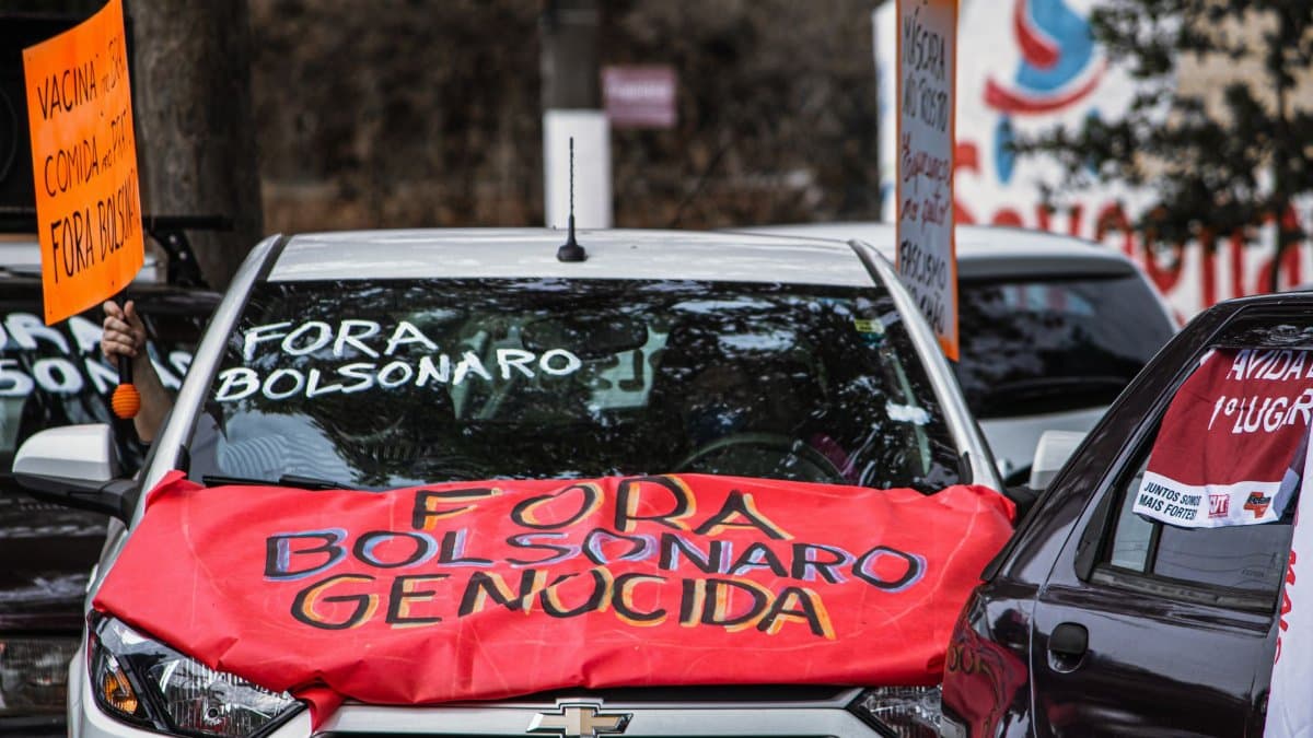 Cars displaying anti-Bolsonaro signs during a street protest, highlighting political activism.