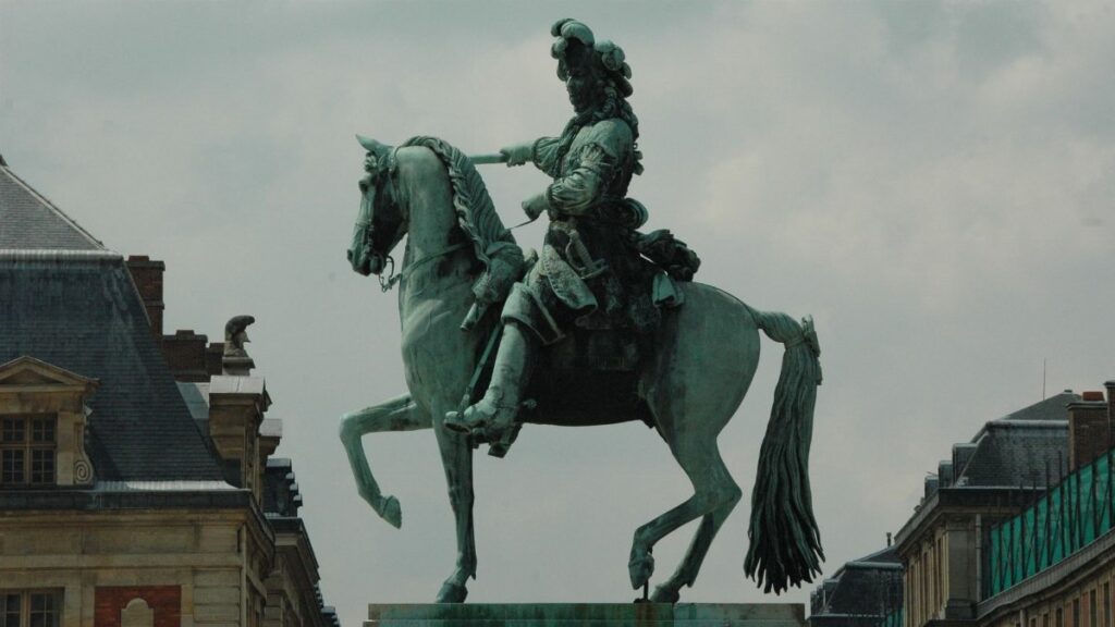 Majestic equestrian statue of Louis XIV against historic French architecture.