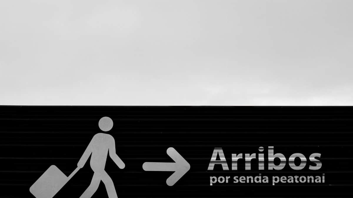 Black and white photo of an airport arrivals sign in Buenos Aires, Argentina.