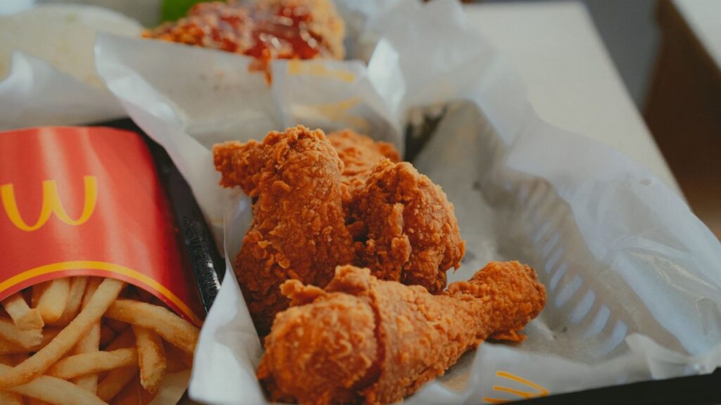 Close-up of crispy fried chicken and fries in a fast food restaurant.