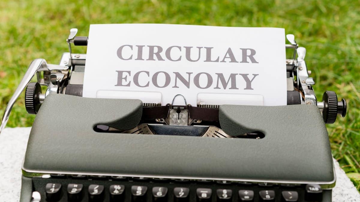 Classic typewriter displaying 'Circular Economy' in outdoor setting, conveying sustainability.