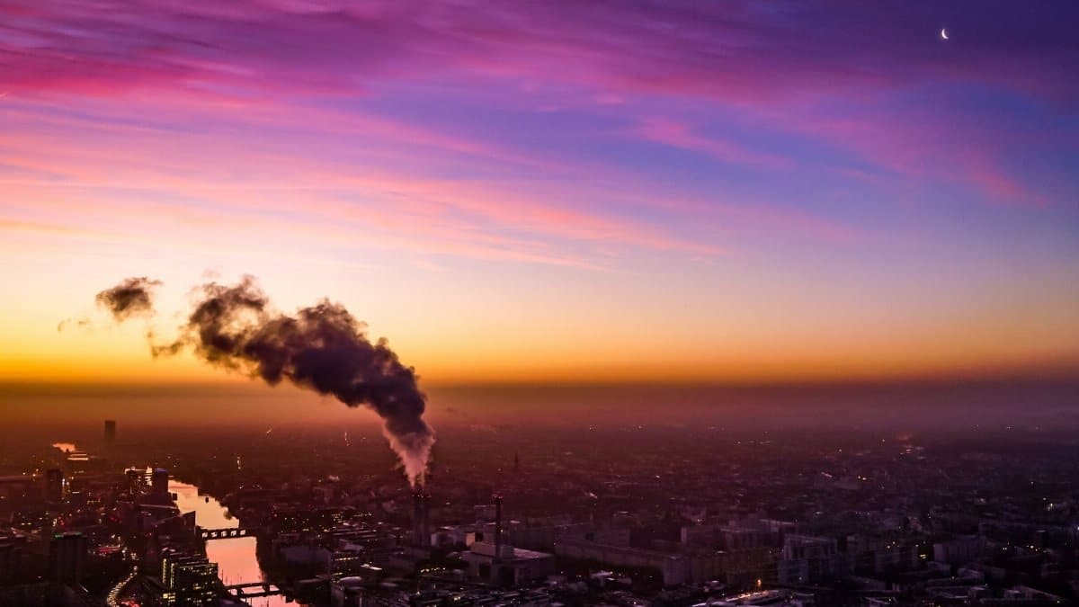 Stunning aerial view of Berlin at sunset with vibrant colors and factory smoke.