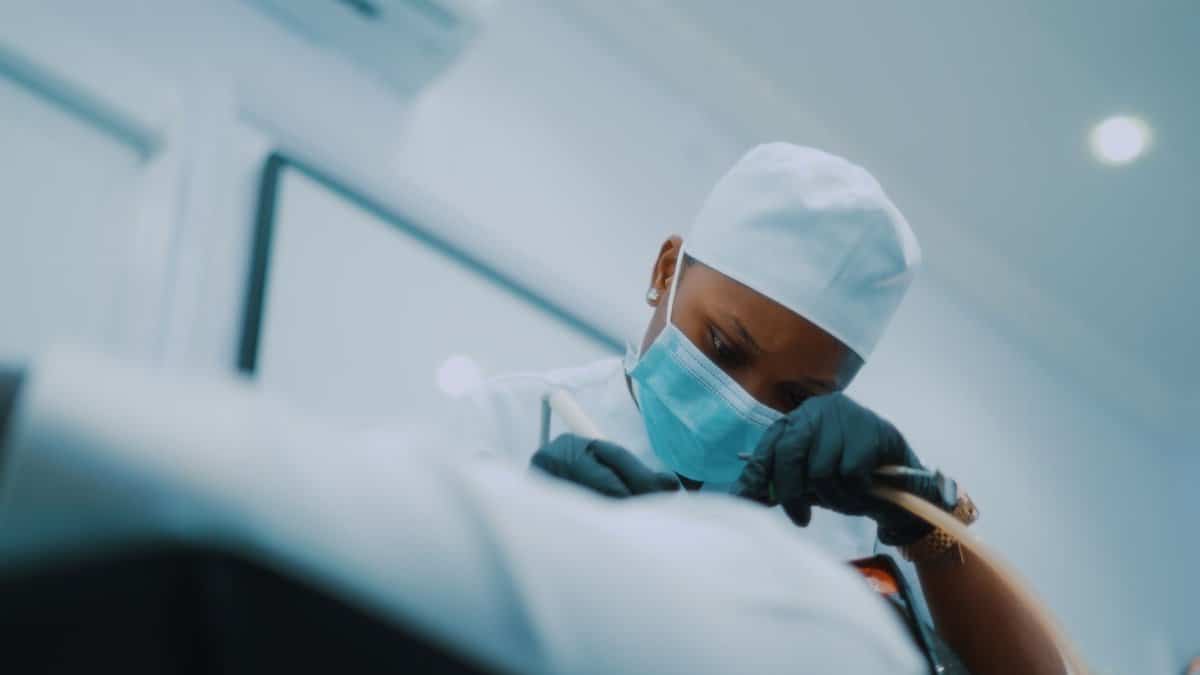 African American surgeon performing a detailed medical procedure in a modern hospital setting.