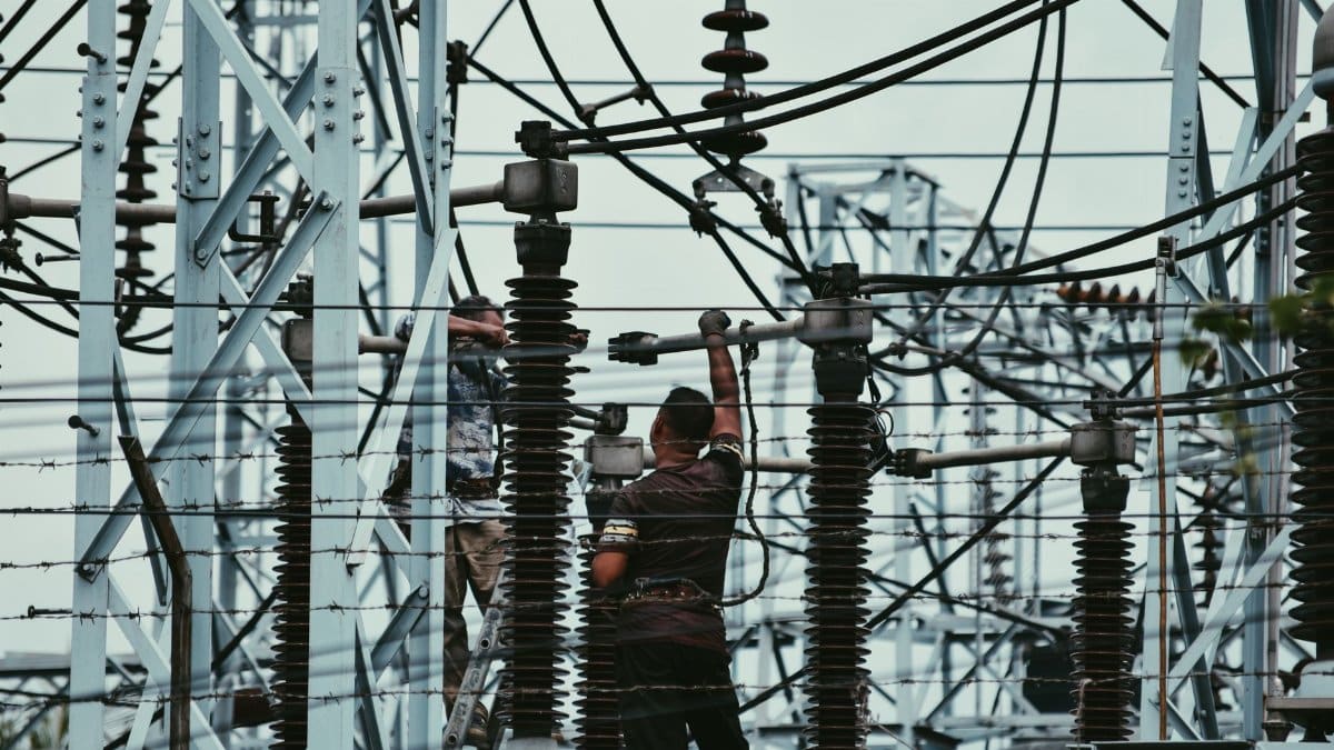 Electricians working on power lines, ensuring grid maintenance and safety.