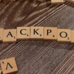Wooden letter tiles spelling 'JACKPOT' on a textured wooden surface, representing winning or success.