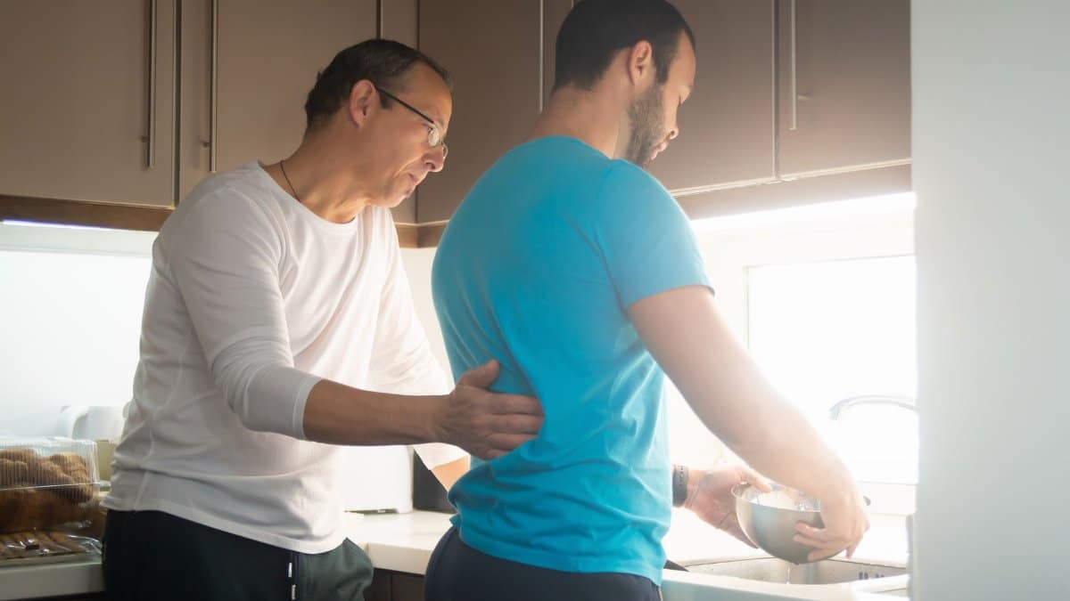 Two men enjoying a moment together while preparing breakfast in a modern kitchen.