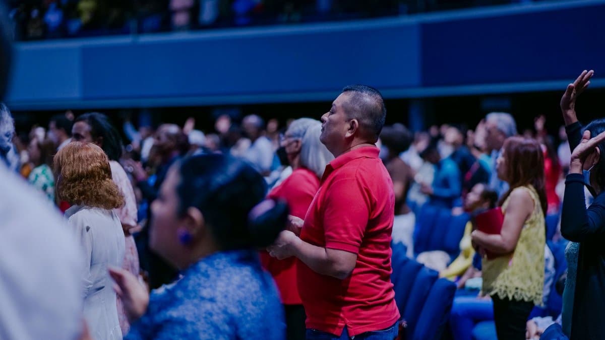 A diverse crowd attentively engaged in an indoor event, creating a lively atmosphere.