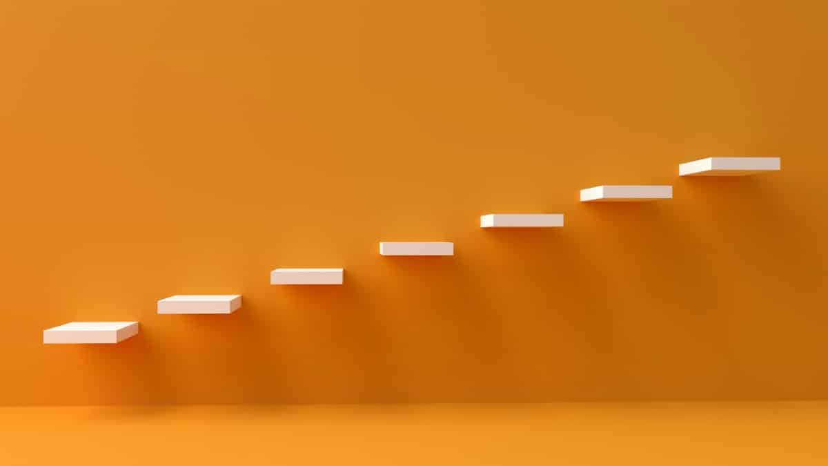 White floating steps on vibrant orange wall create a minimalist and conceptual design.