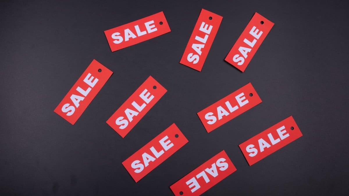 Red sale tags arranged on a dark background, ideal for retail promotions.