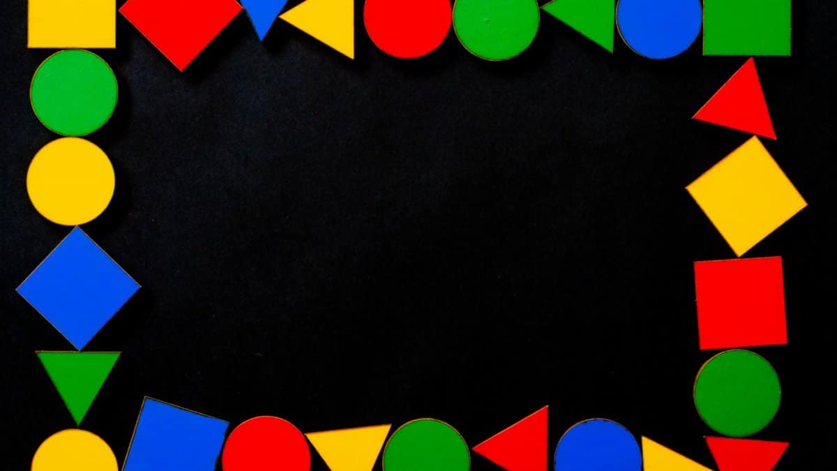 Vibrant geometric shapes create a dynamic frame on a black surface.