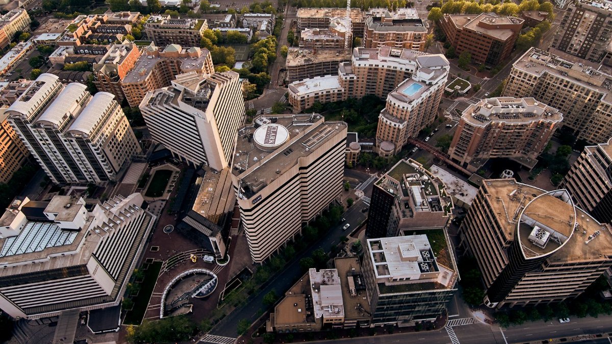 Drone view of creative geometric buildings and green areas in residential district of modern city