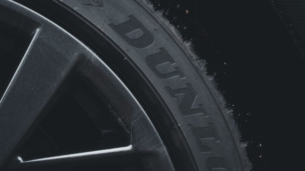 Detailed close-up of a Dunlop tire and rim showcasing its texture and brand text.
