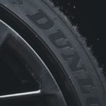 Detailed close-up of a Dunlop tire and rim showcasing its texture and brand text.