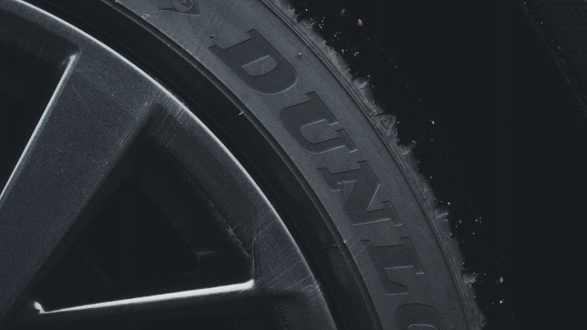 Detailed close-up of a Dunlop tire and rim showcasing its texture and brand text.