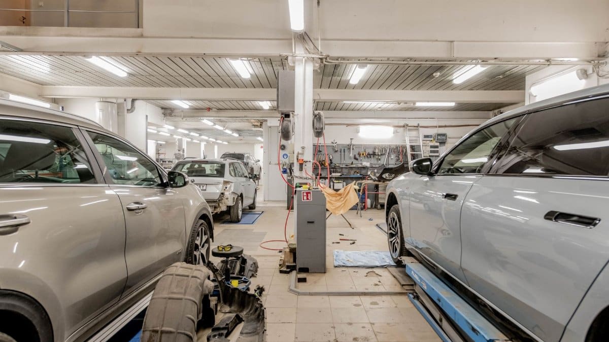 Interior of an automotive repair shop with cars undergoing maintenance and servicing.