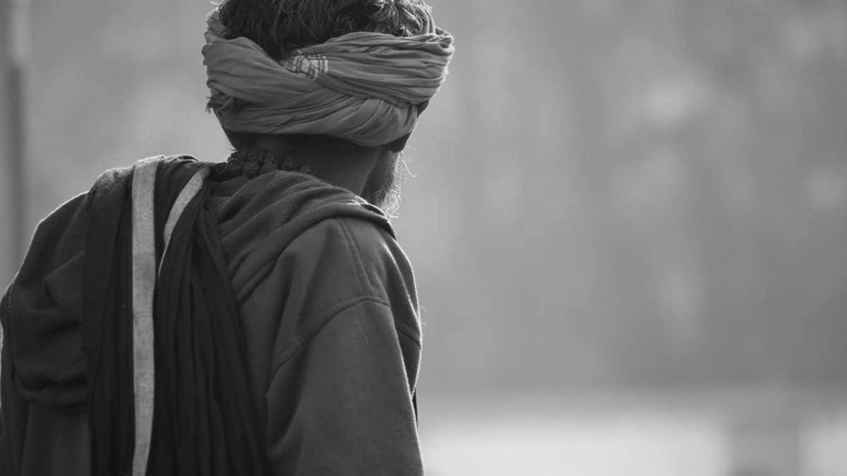 Black and white side profile of a man wearing a turban in Prayagraj, India.