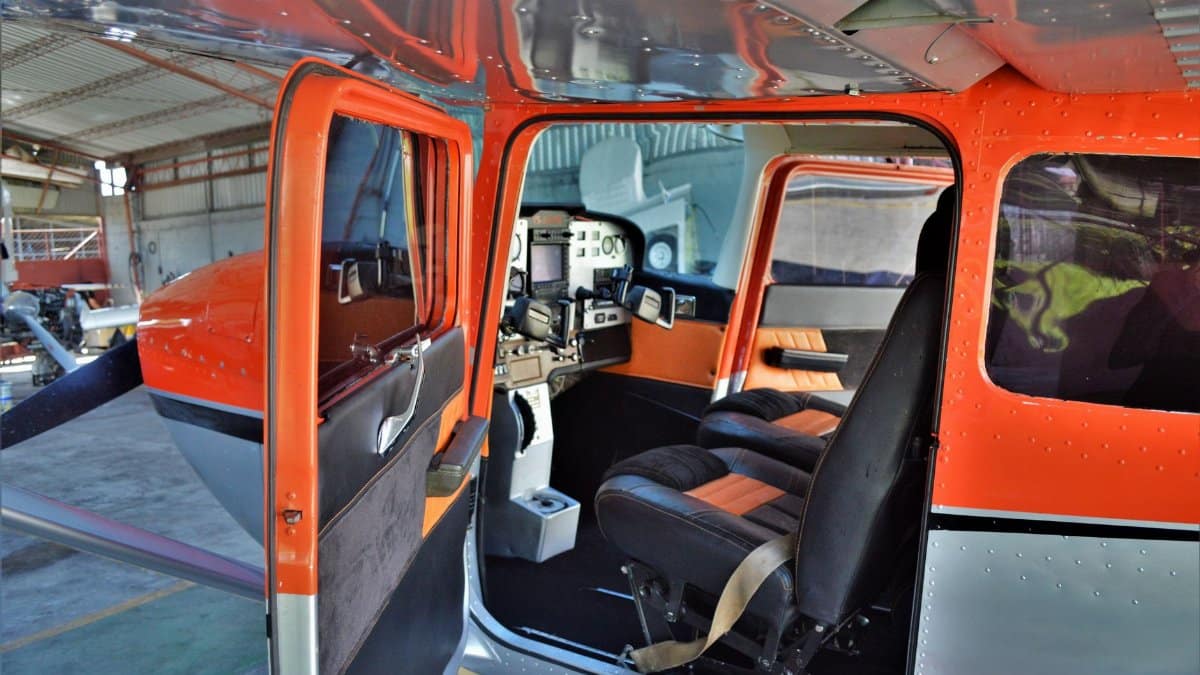 Explore the detailed cockpit of a small private airplane with open door.