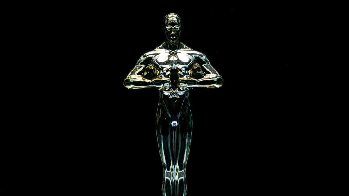 A golden trophy statue isolated on a black background symbolizing achievement and victory.