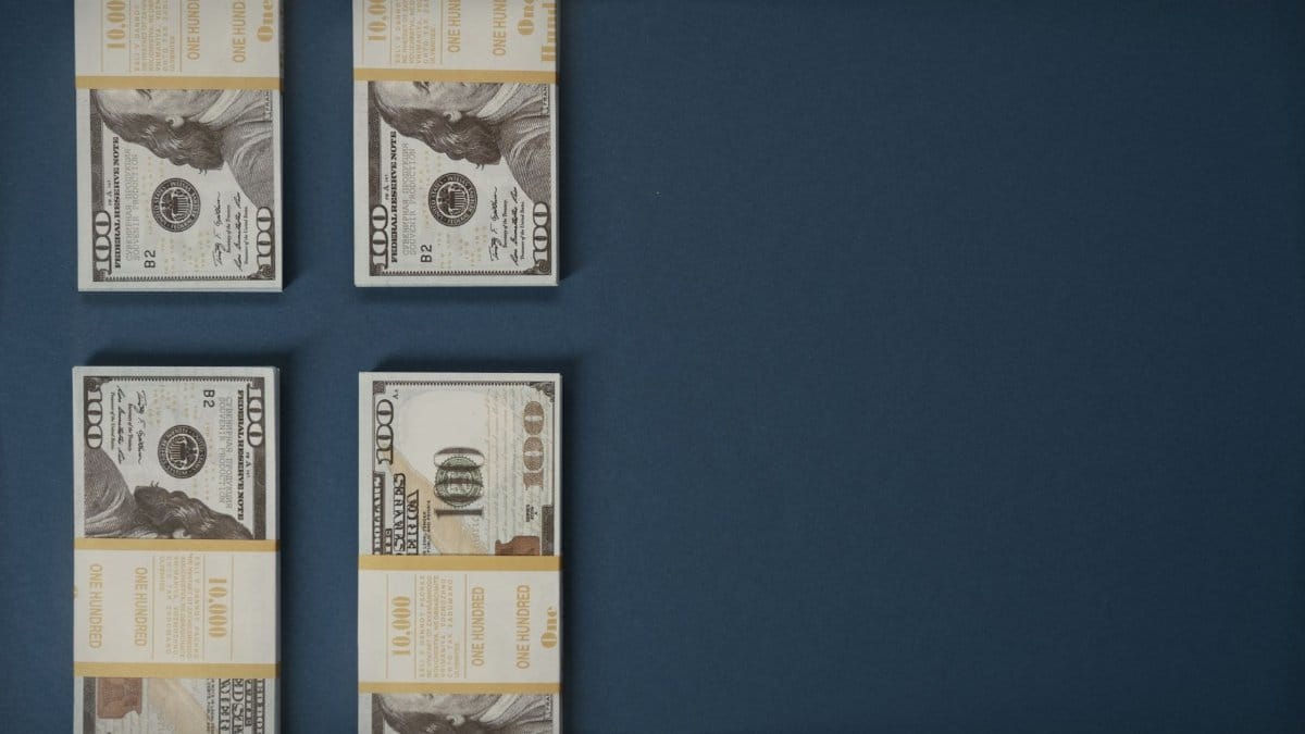 Bundles of US dollar bills neatly stacked on a blue surface, showcasing wealth and finance.