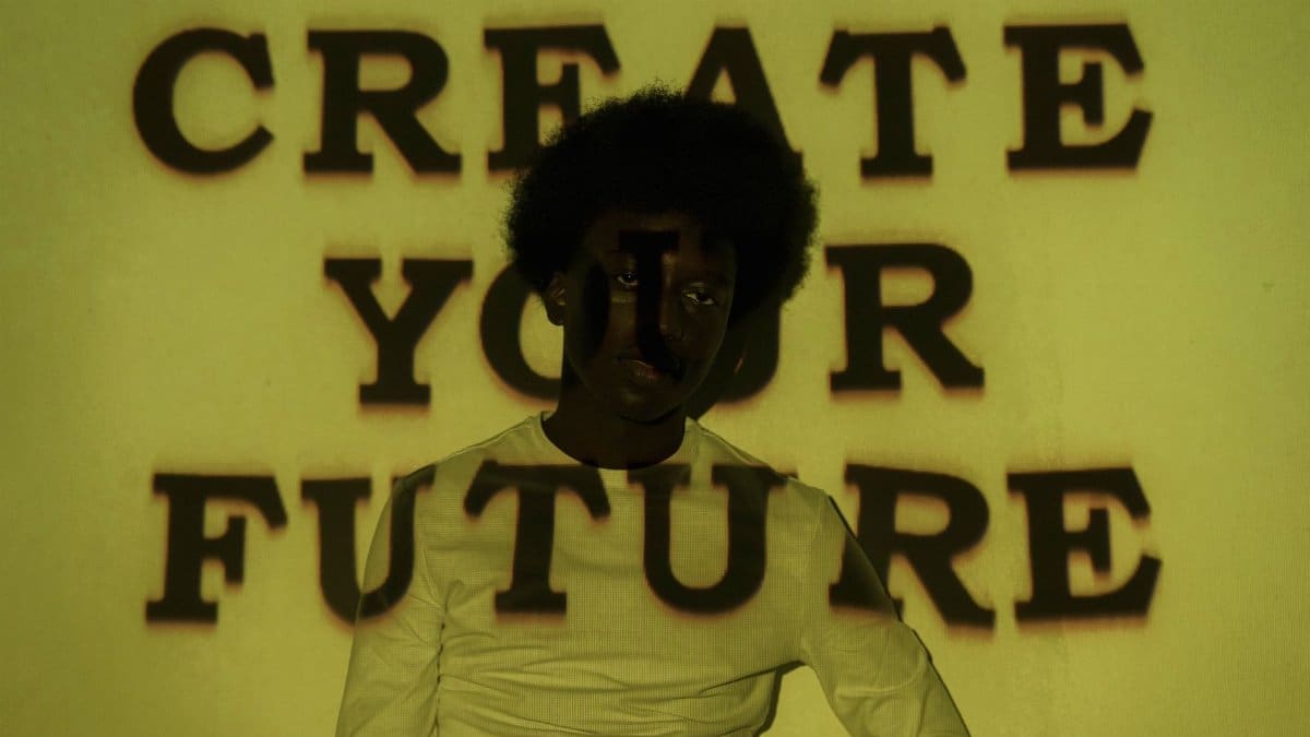A creative portrait with 'Create Your Future' text projected on a person.
