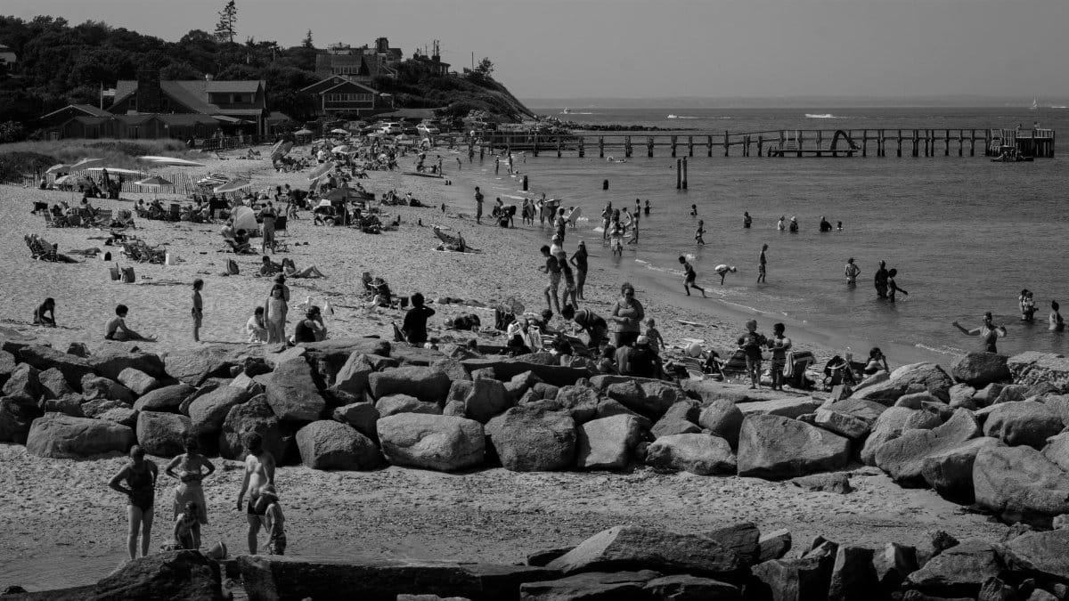 Enjoy a lively black and white scene at Martha's Vineyard beach, capturing summer crowds and shoreline activities.