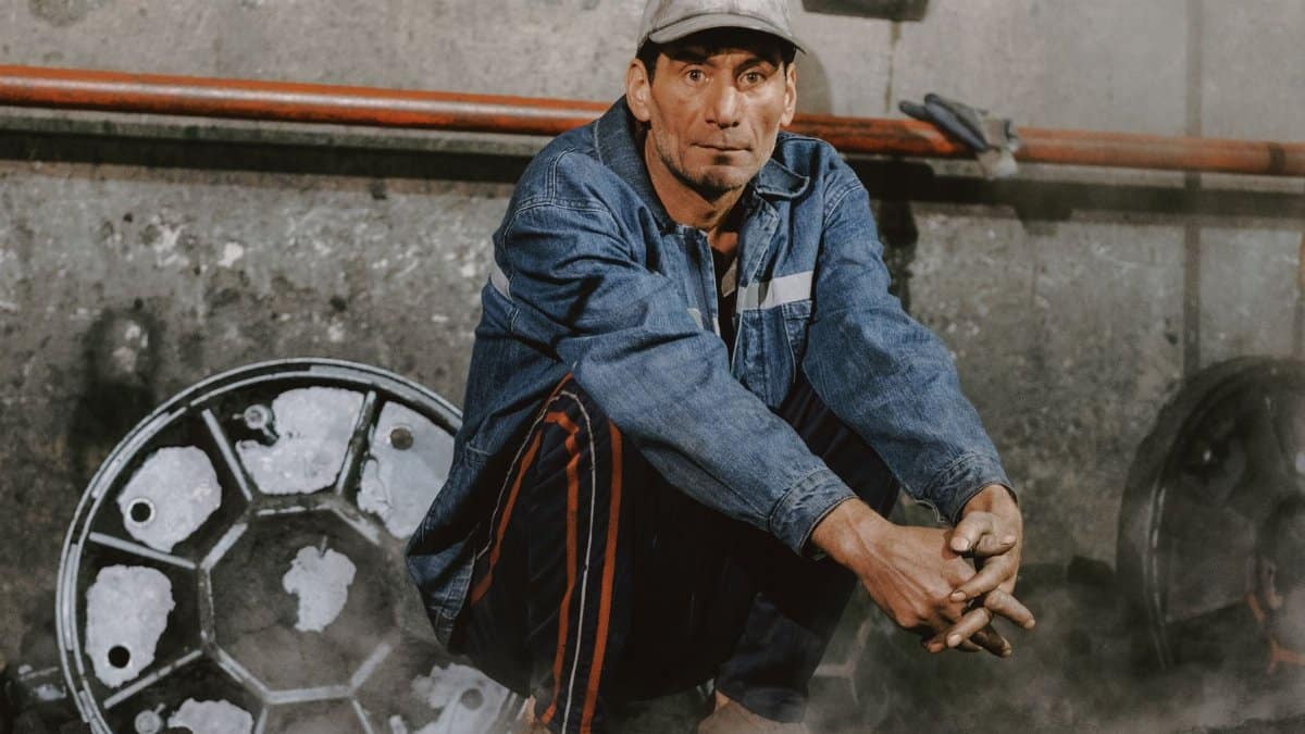 Portrait of a mechanic in an industrial workshop with tools and machinery.