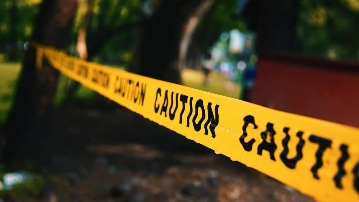 Focused shot of yellow caution tape outdoors, implies warning or danger.