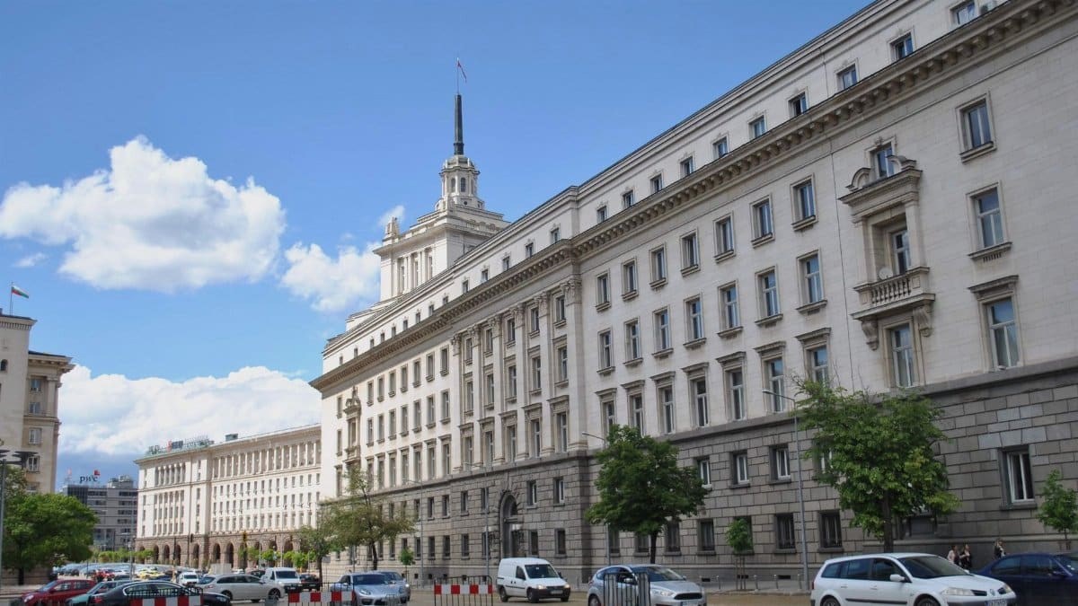Breathtaking view of a historic government building in Sofia, Bulgaria under a bright blue sky.