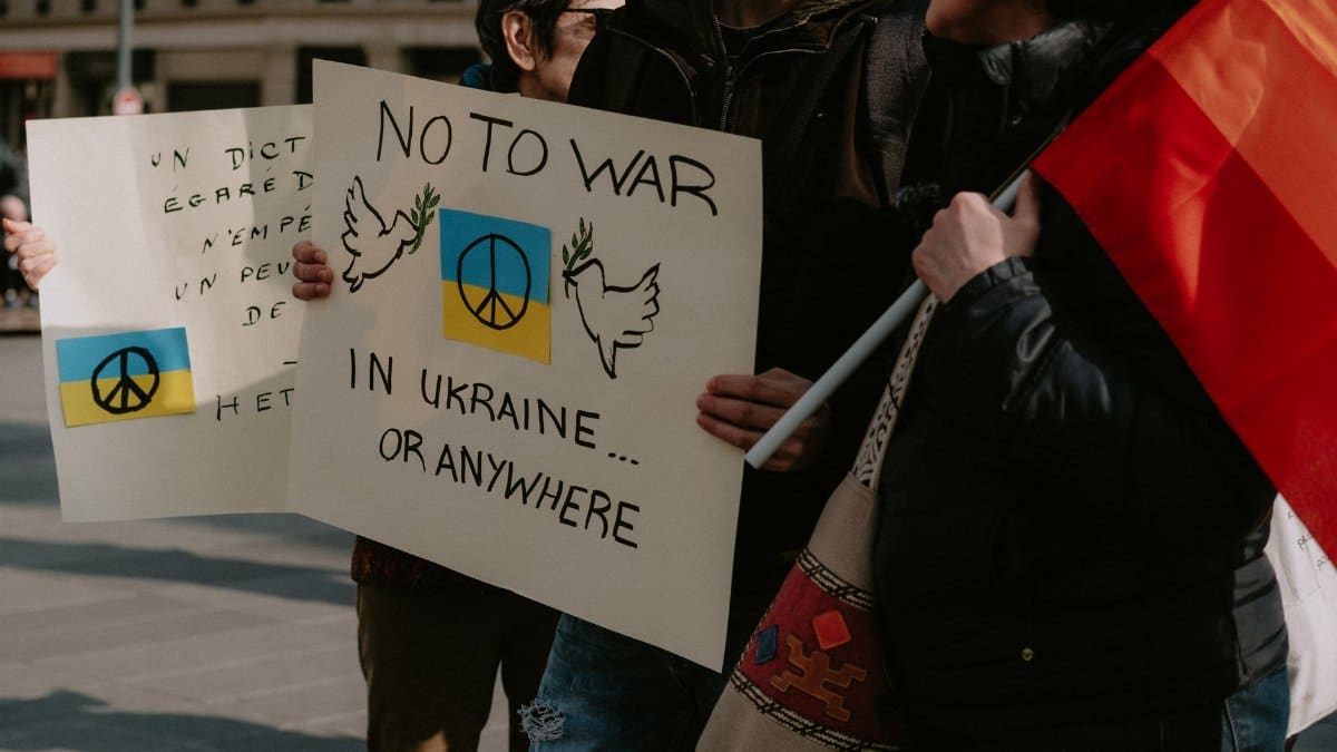 Protesters holding signs advocating for peace in Ukraine and worldwide.